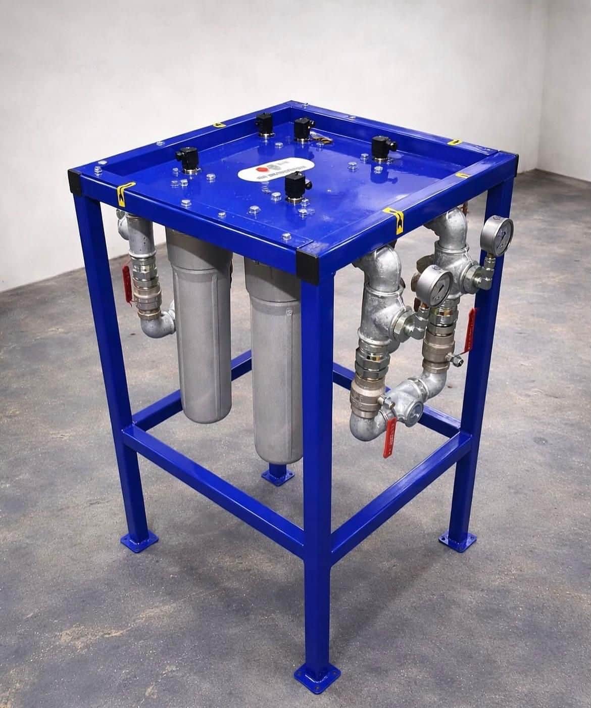 Hydraulic power unit manifold block designed by AEB Engineering — precision pressure gauges, directional control valves, and filter element