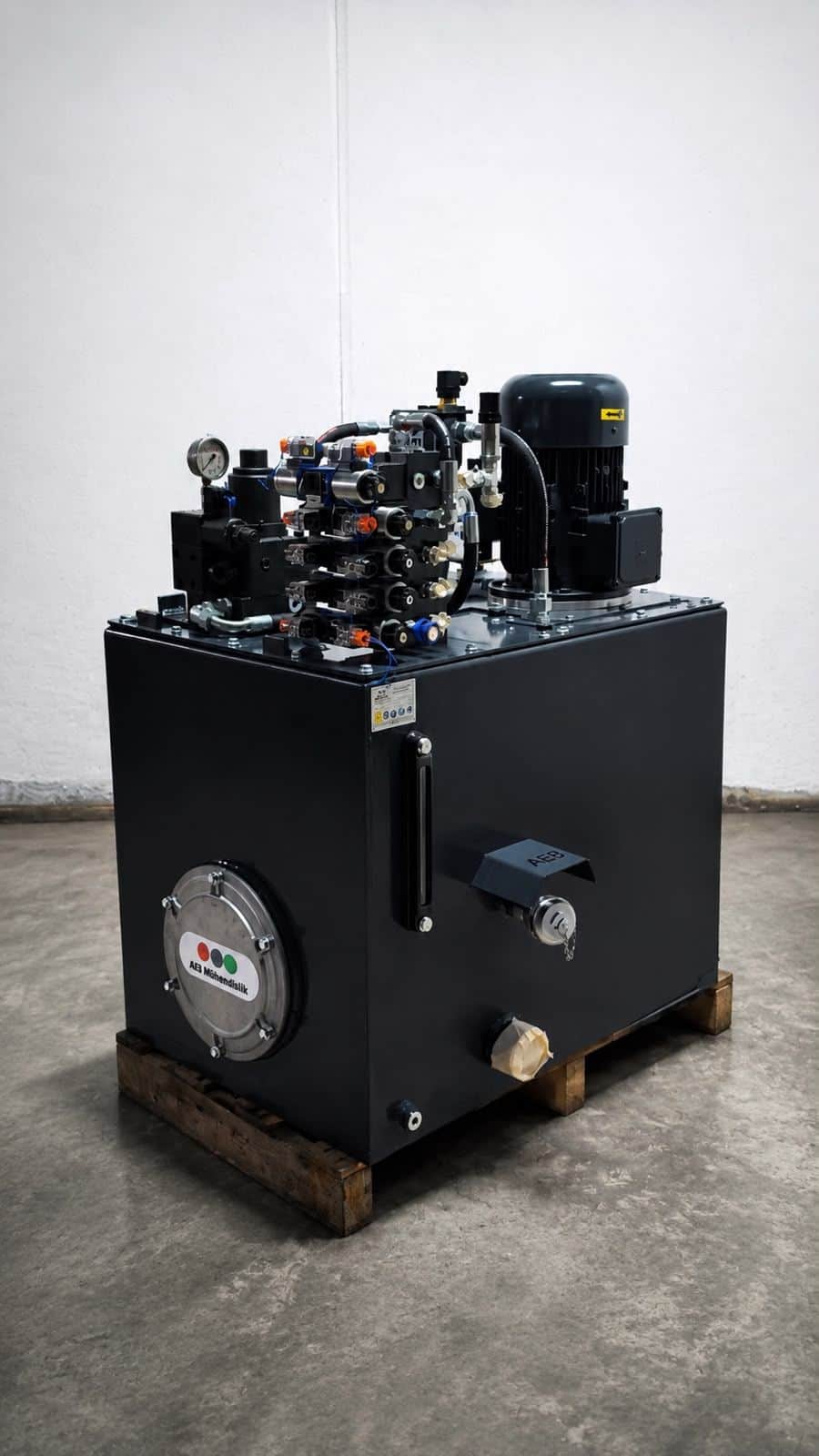 Industrial hydraulic power unit manufactured by AEB Engineering — integrated electrical automation panel, pressure accumulator, and vertical pump system
