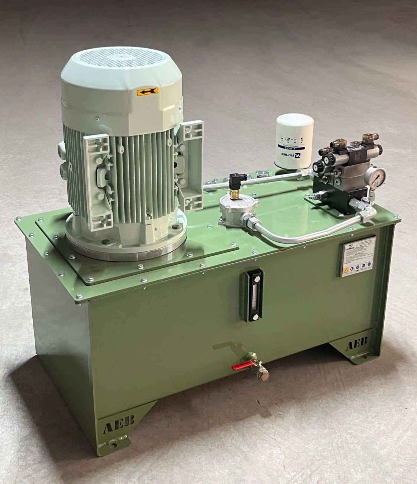 Hydraulically powered unit with vertically mounted electric motor assembled at the AEB Engineering workshop — compact hydraulic tank with suction/return filters and proportional valve block